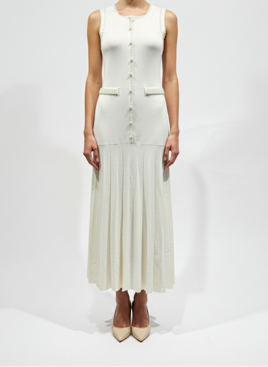 Woman wearing a white sleeveless dress with buttons on a white background