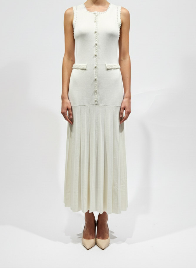 Woman wearing a white sleeveless dress with buttons on a white background